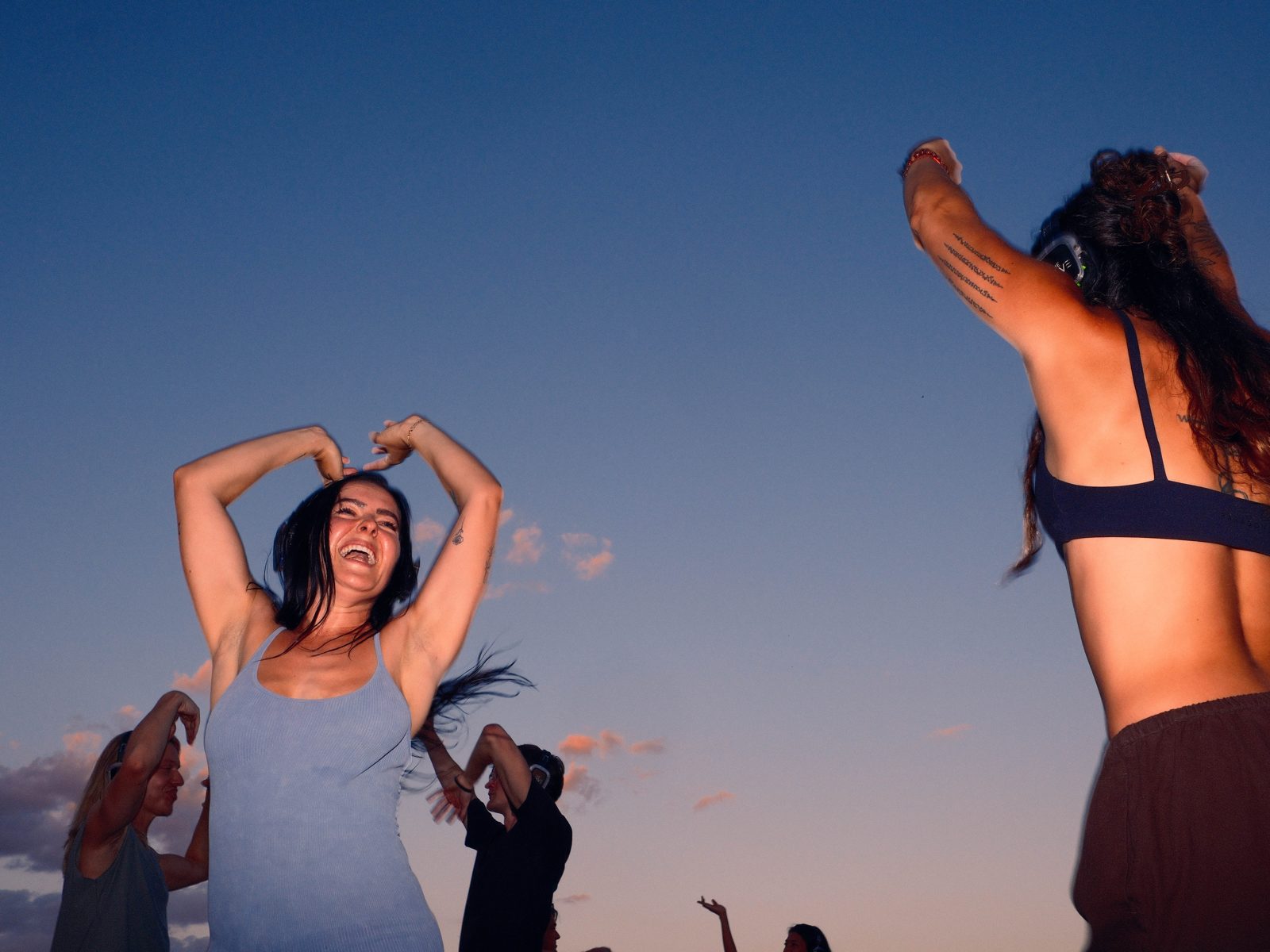 Joyful group dancing together with arms in the air