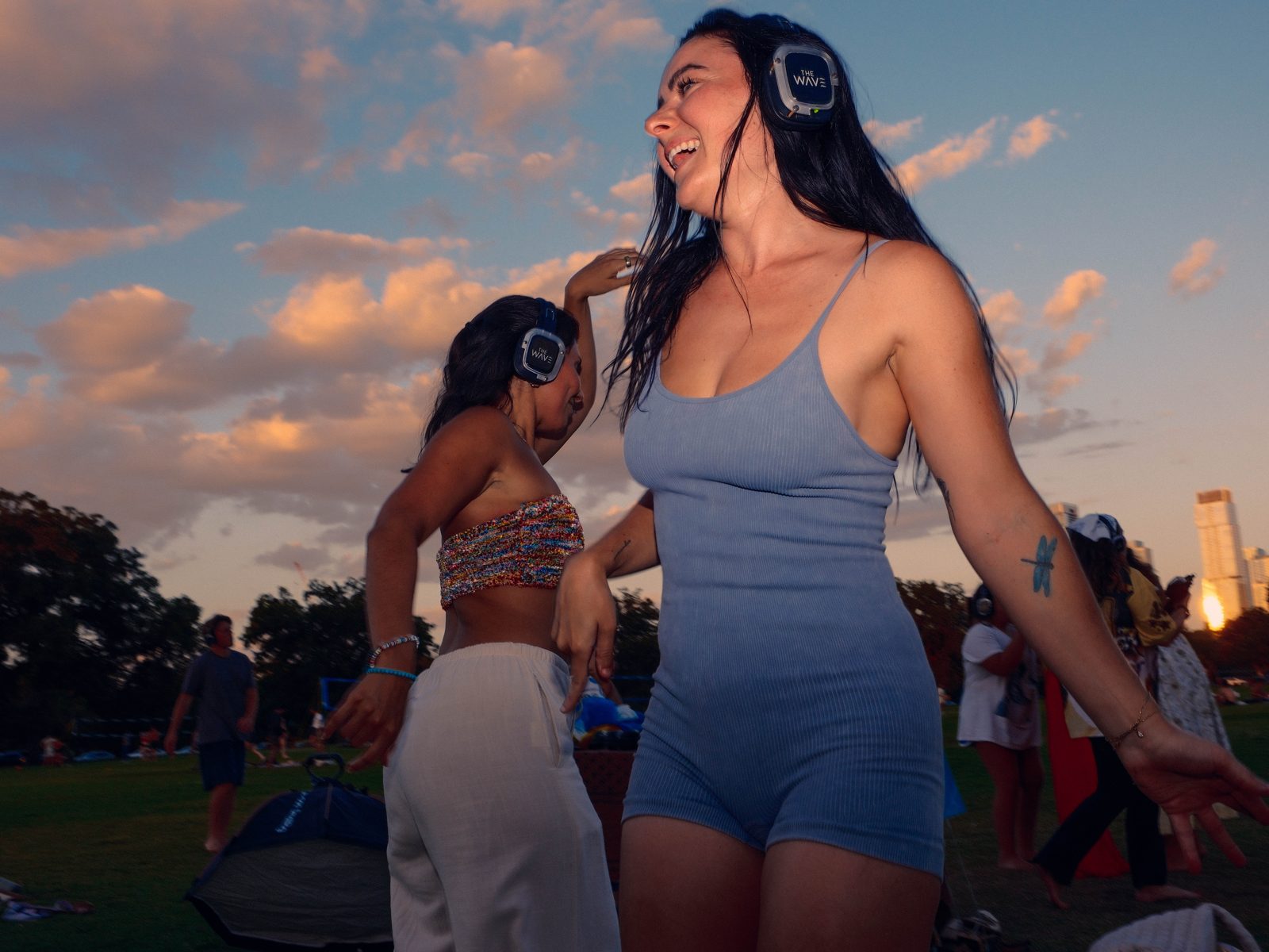 Two dancers moving together against the Austin skyline at golden hour