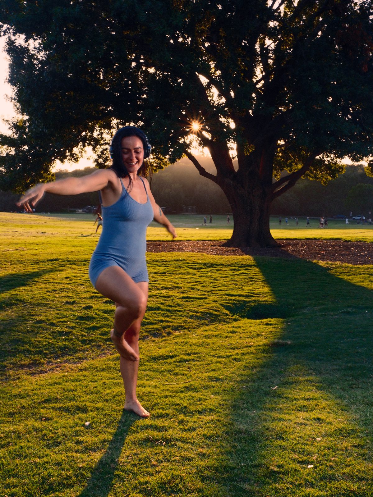 A dancer in a flowing pose bathed in sunset gold