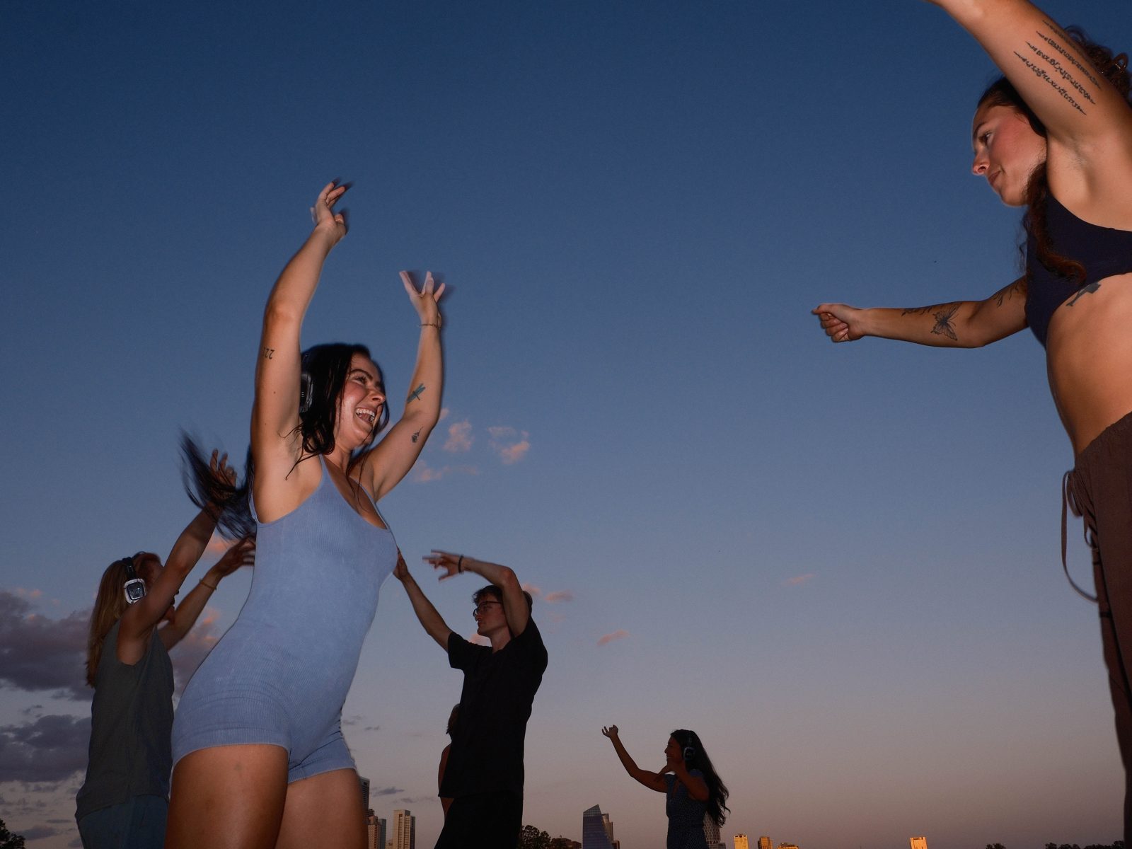 A crowd dancing together with headphones at a park silent disco